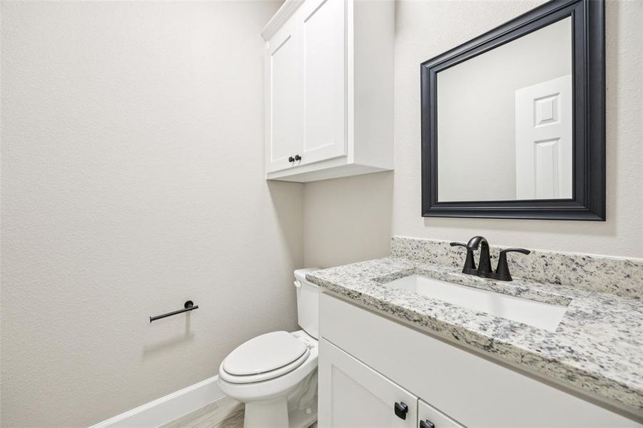 Bathroom with vanity, wood finished floors, and a textured wall Bathroom with vanity, wood finished floors, and a textured wall