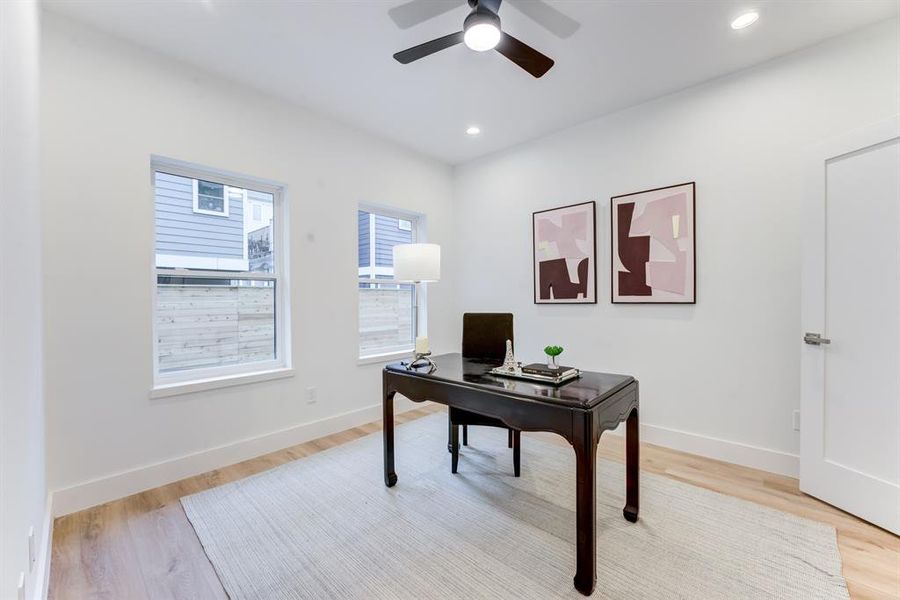 First floor bedroom with en-suite bathroom, ceiling fan, recessed lighting, and luxury vinyl plank flooring. The 2 large double paned windows bring in an abundance of natural light.