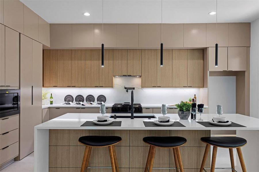 Kitchen with a kitchen island with sink, black microwave, decorative backsplash, and light brown cabinetry