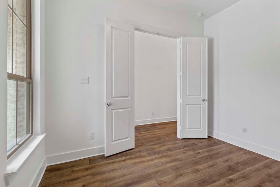 Unfurnished bedroom with baseboards and dark wood-style flooring Unfurnished bedroom with baseboards and dark wood-style flooring