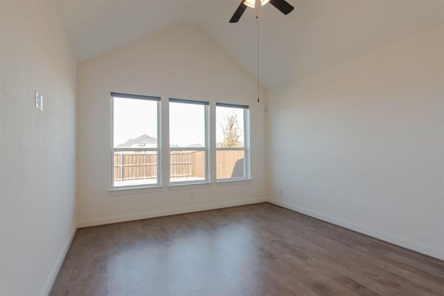 Unfurnished room with hardwood / wood-style floors, ceiling fan, and high vaulted ceiling