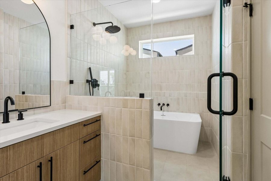A freestanding soaking tub and oversized walk in shower wrapped in designer tile create a spa inspired space designed to begin and end each day with ease. A freestanding soaking tub and oversized walk in shower wrapped in designer tile create a spa inspired space designed to begin and end each day with ease.