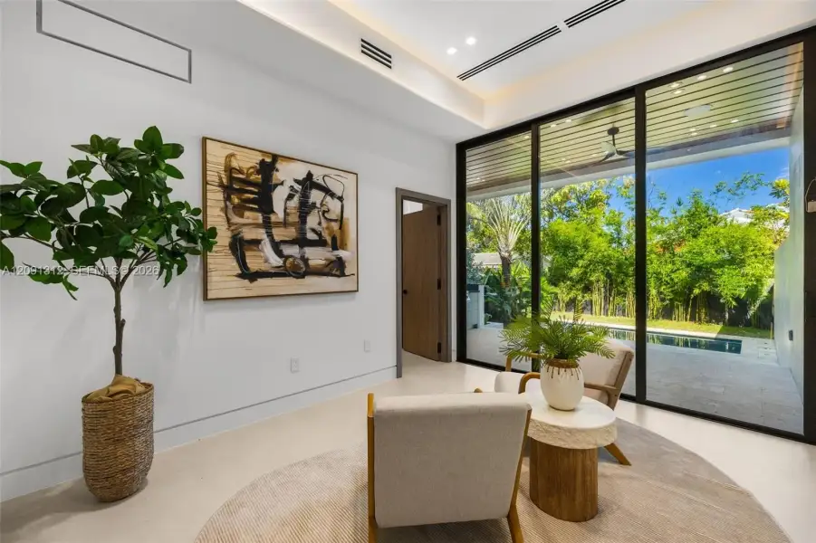 Floor-to-ceiling sliding glass walls, recessed cove lighting, linear ceiling vents, and smooth-finish flooring Floor-to-ceiling sliding glass walls, recessed cove lighting, linear ceiling vents, and smooth-finish flooring
