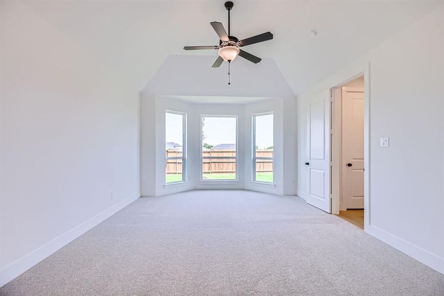 Spare room featuring light colored carpet, baseboards, ceiling fan, and lofted ceiling Spare room featuring light colored carpet, baseboards, ceiling fan, and lofted ceiling
