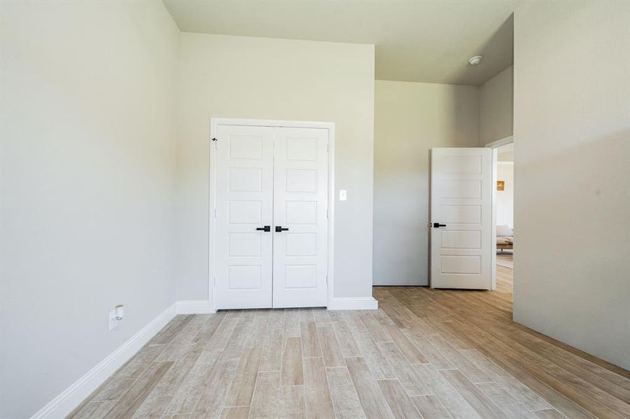 Unfurnished bedroom featuring light wood-style floors and a closet Unfurnished bedroom featuring light wood-style floors and a closet