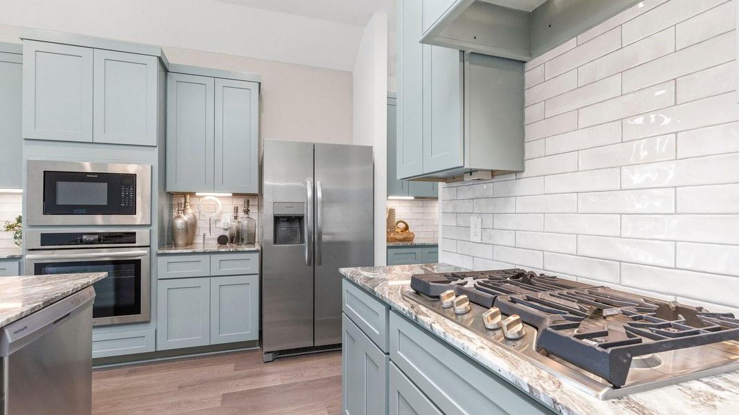 Bright and spacious kitchen with granite countertops, stainless steel appliances, and an island with bar seating. Bright and spacious kitchen with granite countertops, stainless steel appliances, and an island with bar seating.