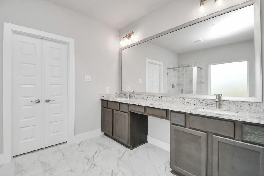 Alternative view of the expansive primary bathroom, showcasing a dedicated vanity area with double sinks, framed mirror, sophisticated and modern finishes that redefine luxury. Sample photo of completed home with similar floor plan. Actual colors and selections may vary. Alternative view of the expansive primary bathroom, showcasing a dedicated vanity area with double sinks, framed mirror, sophisticated and modern finishes that redefine luxury. Sample photo of completed home with similar floor plan. Actual colors and selections may vary.