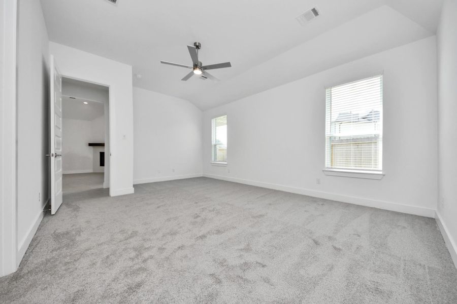 Come and unwind after a long day in this magnificent primary suite! This spacious room features plush carpet, warm paint, high ceilings and large windows with privacy blinds.