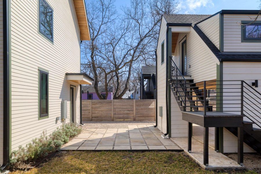View of side of home featuring a shingled roof and a patio
