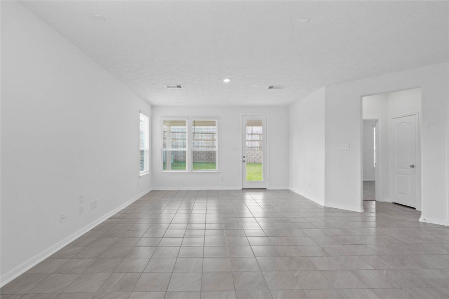 Bring family and friends together in this beautiful Great Room! It features soaring ceilings, recessed lighting, custom paint, tile flooring, and large windows that fill the space with natural light!