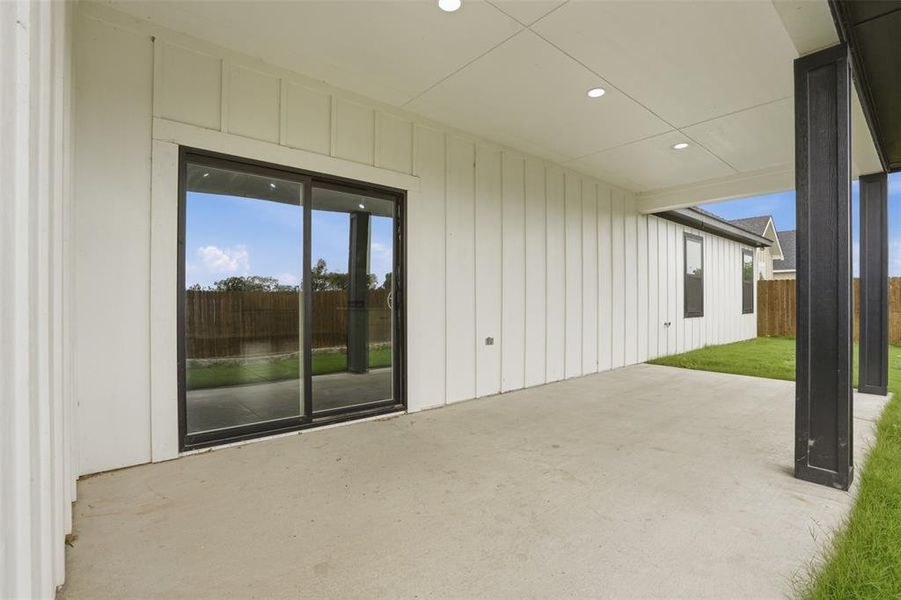 Covered patio featuring a concrete slab, recessed lighting, and black support columns