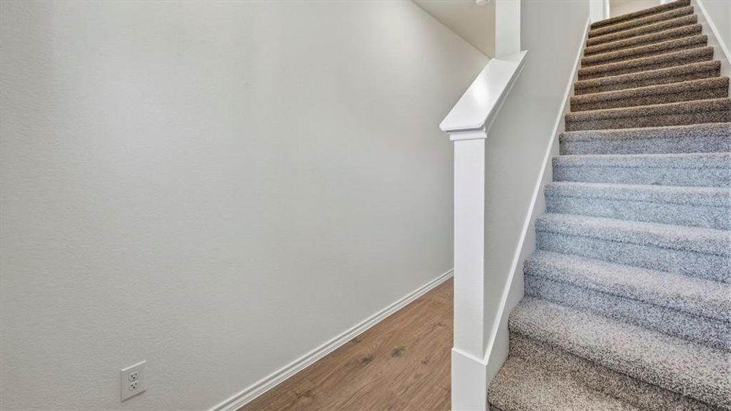 Staircase featuring baseboards and wood finished floors