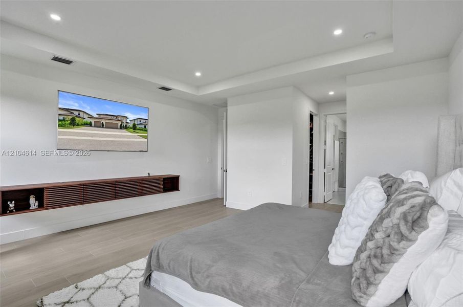 Recessed lighting, tray ceiling, wood-look flooring