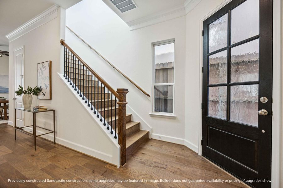 Hello, modern welcome moment! This front entry sets the tone with warm wood tones, a statement staircase, and sunlight that practically greets you at the door.