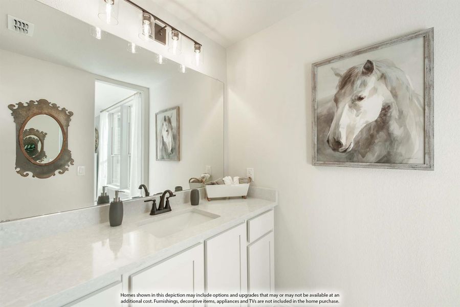 Bathroom vanity with white cabinets, quartz countertop, large mirror, and bar lighting above sink