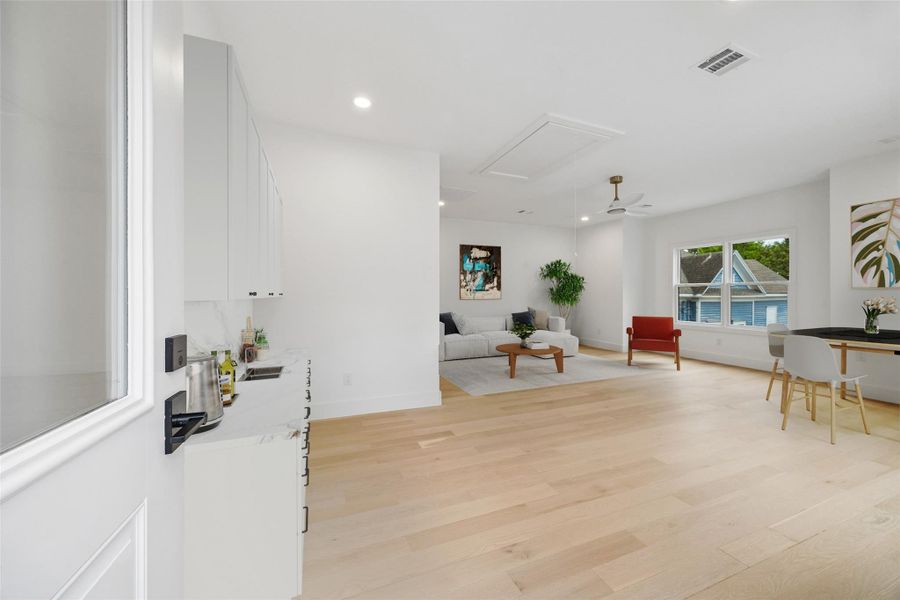 The garage apartment includes future water access for a potential kitchenette addition, creating long-term flexibility for extended guest use or independent living arrangements. Large windows and French doors bring in natural light while overlooking the surrounding greenery near Marmion Park. Kitchenette shown is digitally staged for visual reference only. (digitally staged)
