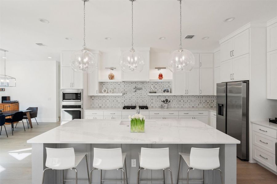 Upscale kitchen finish out selections include Quartz countertops, marble tile backsplash, Samsung appliances, high-end cabinet pulls. Don't miss the beverage refrigerator on the right and pot filler above the gas cooktop!