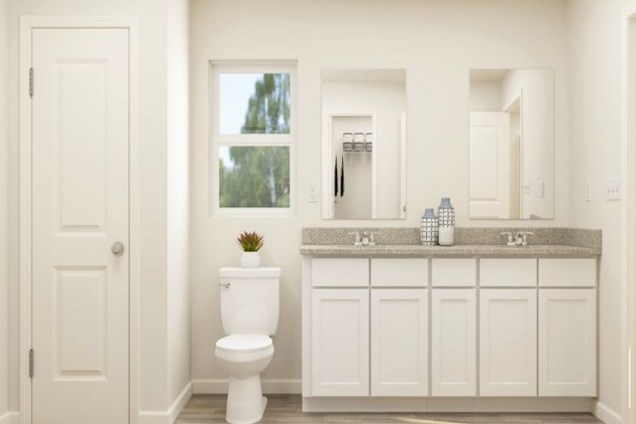 A bathroom with white cabinets.