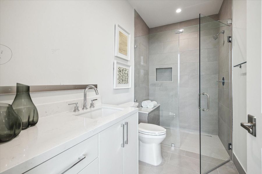 En-suite bathroom with a walk-in shower. Photos are of a similar unit with the same floor plan