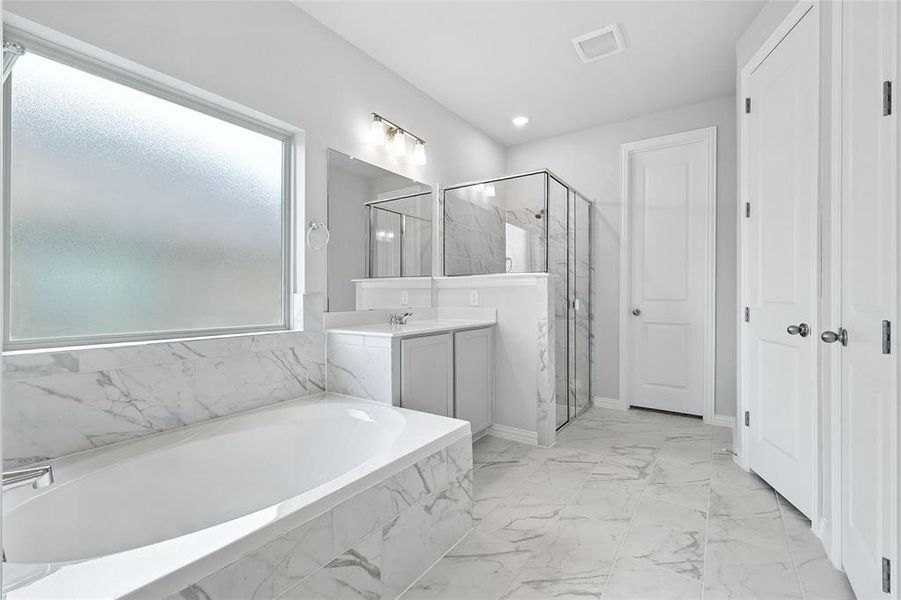 Full bathroom with a garden tub, a marble finish shower, vanity, and marble finish floors Full bathroom with a garden tub, a marble finish shower, vanity, and marble finish floors
