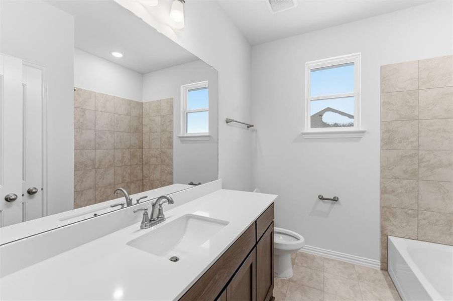 Bathroom featuring vanity, light tile patterned floors, and bathtub / shower combination Bathroom featuring vanity, light tile patterned floors, and bathtub / shower combination