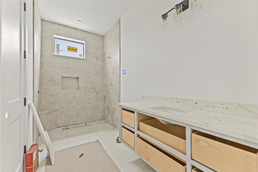 Bathroom featuring a tiled shower enclosure with a recessed niche and window