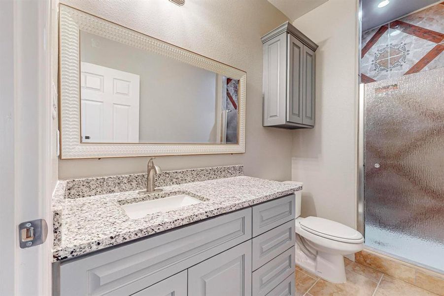 Bathroom featuring toilet, tile flooring, and large vanity