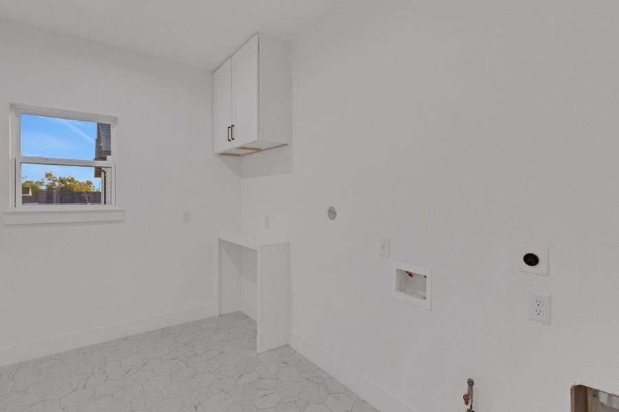 Oversized utility room with hexagon tile flooring, upper cabinetry, and dedicated space for washer and dryer that marries functionality with style. Oversized utility room with hexagon tile flooring, upper cabinetry, and dedicated space for washer and dryer that marries functionality with style.