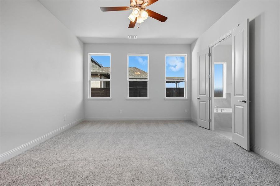 Unfurnished bedroom featuring light colored carpet and a ceiling fan