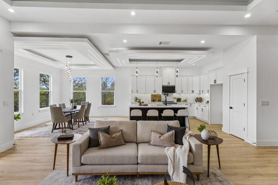 Gleaming hardwood floors and a modern open floorplan connect the airy living, dining, and kitchen areas.