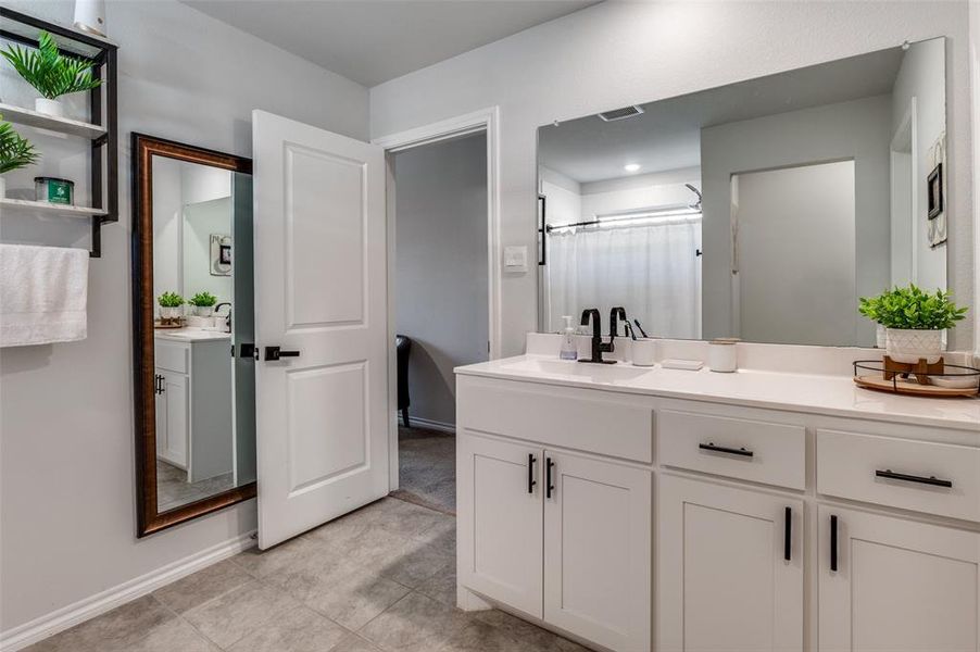 Full bath featuring vanity, and light tile patterned floors