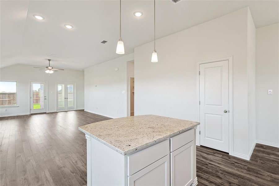 Kitchen with hanging light fixtures, white cabinetry, dark hardwood / wood-style floors, and ceiling fan