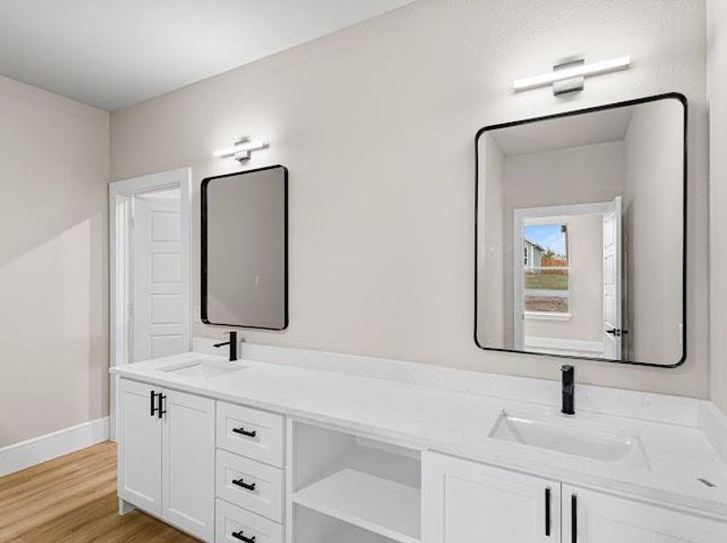 Full bathroom featuring double vanity and light wood finished floors Full bathroom featuring double vanity and light wood finished floors