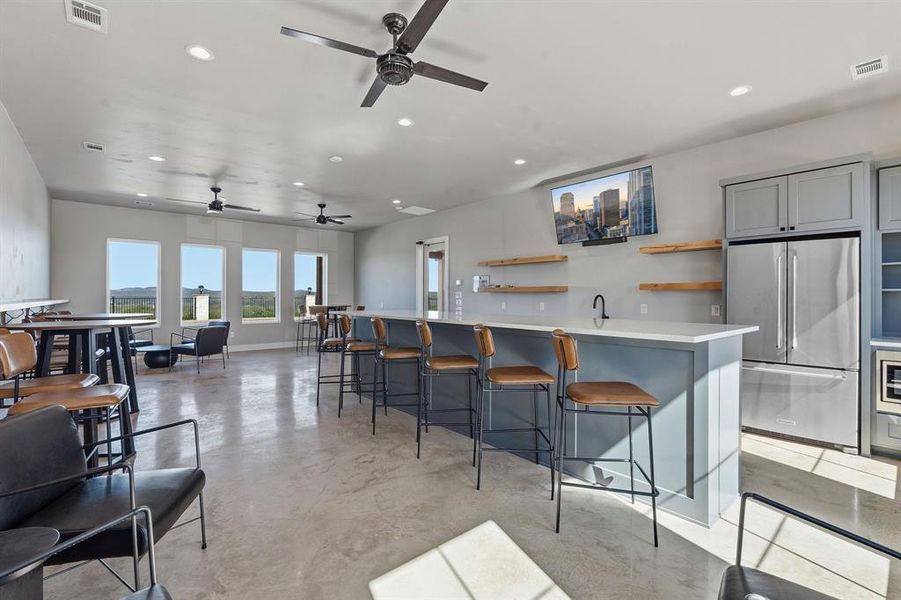 Sun-filled common area with a spacious bar and ample seating offers panoramic outdoor views.