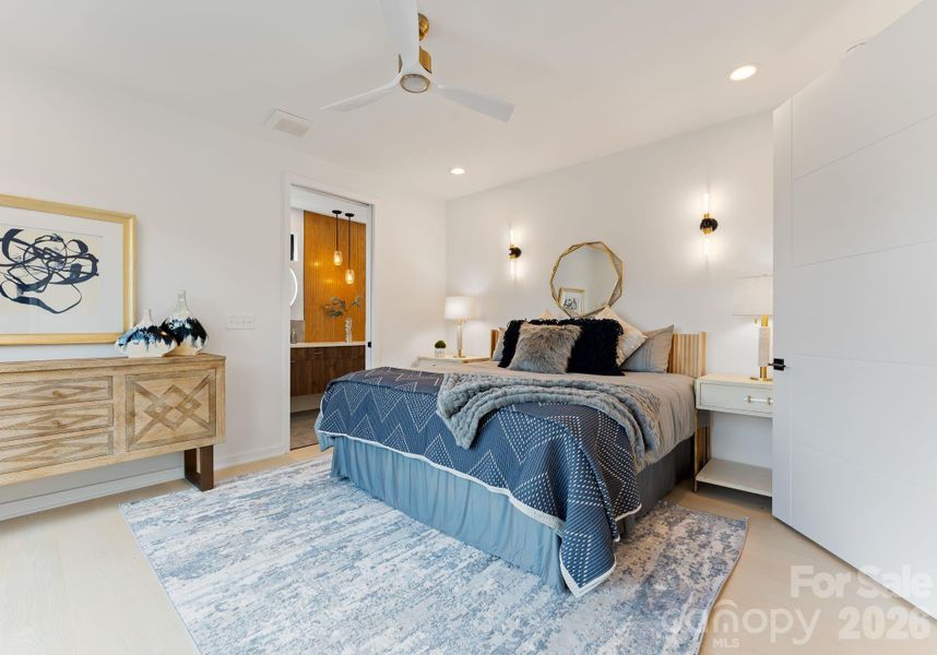 Primary bedroom with sconce lighting.