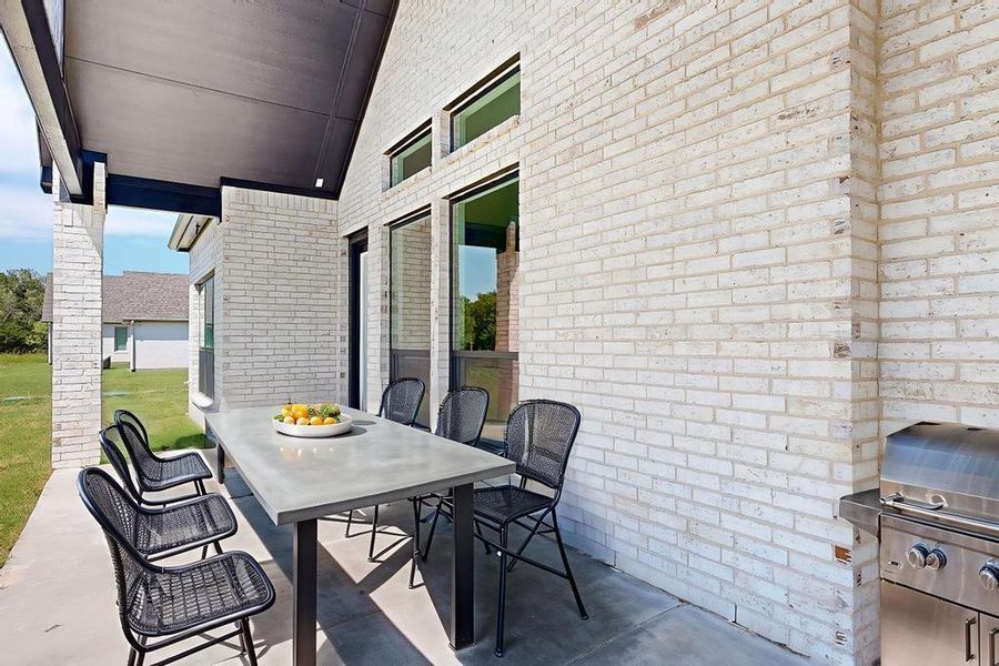 View of patio with outdoor dining area and a grill