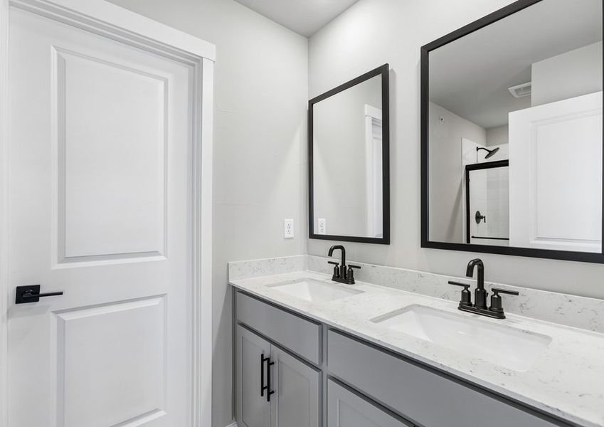 The master bathroom has a dual sink vanity and a step in shower.