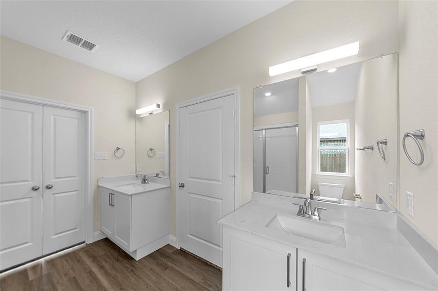 Dual vanity with white cabinetry, integrated sinks, chrome fixtures, and quartz countertops