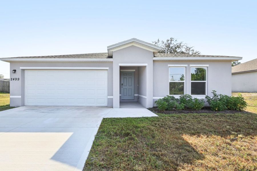 Front exterior of a new home in Palm Bay Classic, Palm Bay, FL, highlighting curb appeal (Image 1). Front exterior of a new home in Palm Bay Classic, Palm Bay, FL, highlighting curb appeal (Image 1).