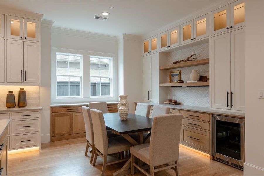 Kitchen dining nook with custom cabinets and wine cooler.  Plumbed for an Ice Maker.