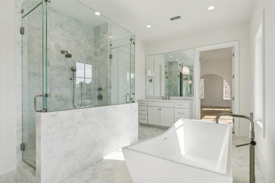 Bathroom featuring vanity and shower with separate bathtub