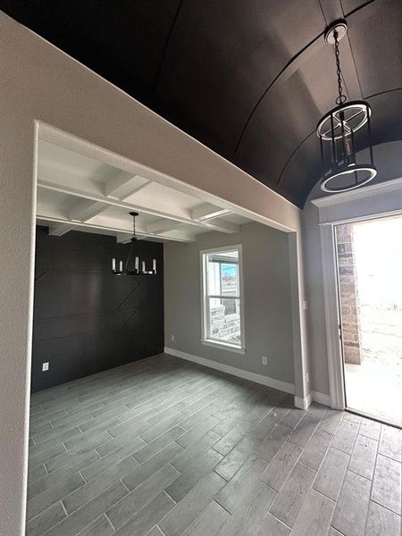 Empty room with beam ceiling, baseboards, and wood finish floors