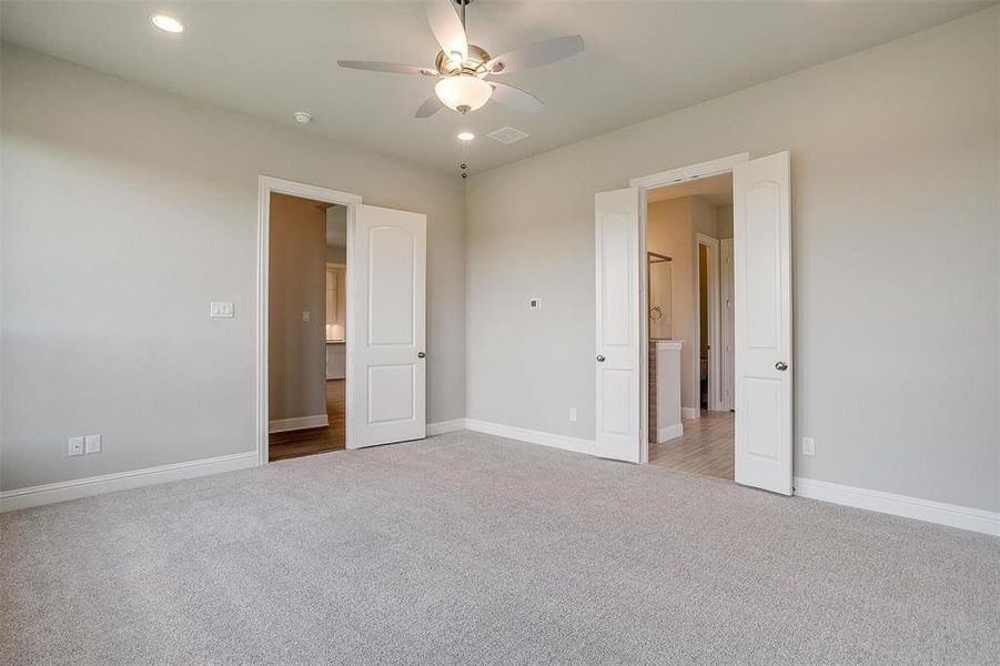 Unfurnished bedroom featuring carpet floors and ceiling fan