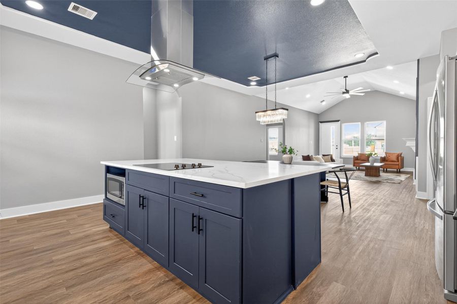 Large kitchen island with cooktop open to the living room and dining area. Large kitchen island with cooktop open to the living room and dining area.
