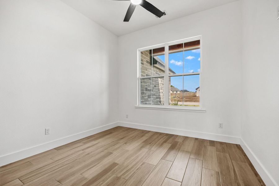 Spare room with wood finish floors and a ceiling fan