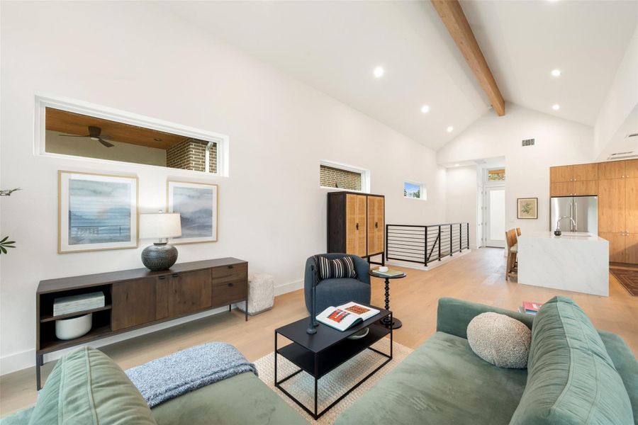Vast vaulted ceilings and recessed lighting create an open, airy atmosphere within this contemporary living area. Vast vaulted ceilings and recessed lighting create an open, airy atmosphere within this contemporary living area.