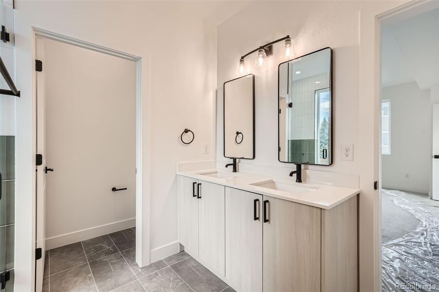 Primary ensuite with double vanity, designer finishes, and quartz countertops(NOTE: This home has a darker color scheme. See finishes for details.)