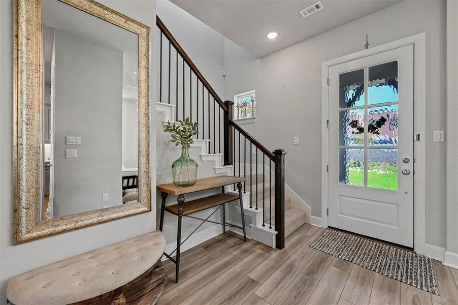 Foyer with wood finished floors, stairway, and recessed lighting Foyer with wood finished floors, stairway, and recessed lighting