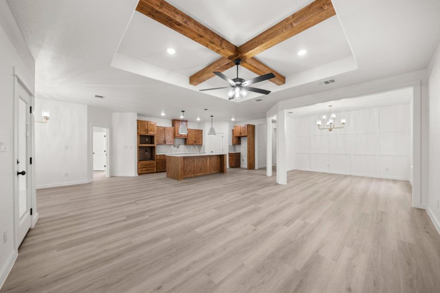 An open floorplan seamlessly connects the kitchen and dining areas, illuminated by recessed lighting and a striking ceiling fan. An open floorplan seamlessly connects the kitchen and dining areas, illuminated by recessed lighting and a striking ceiling fan.