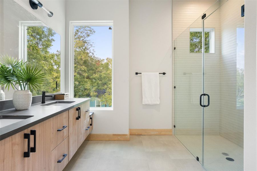 Bathroom featuring a stall shower and double vanity Bathroom featuring a stall shower and double vanity
